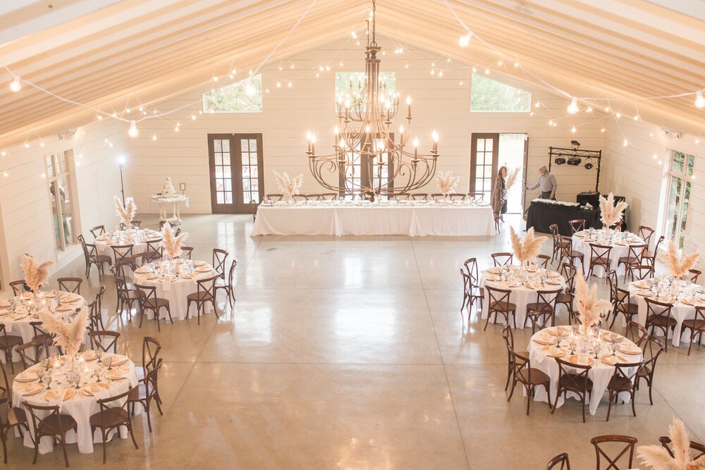 indoor wedding reception with wooden tables and chairs