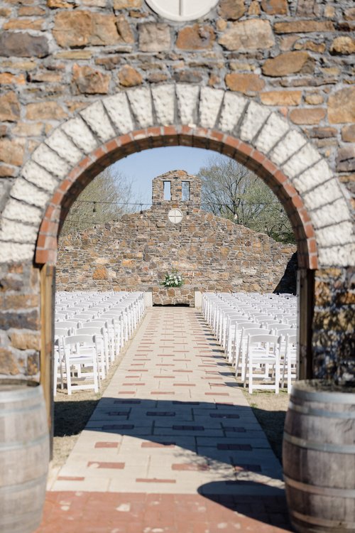 outdoor wedding ceremony under stone archway