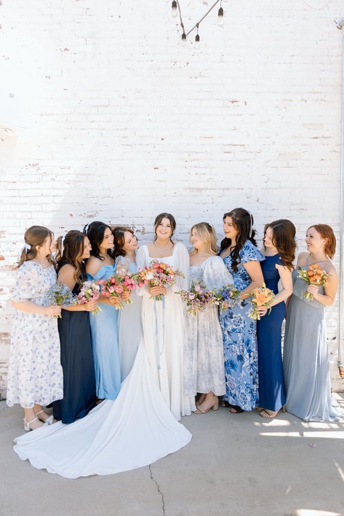 bride with bridesmaids in mismatched blue dresses