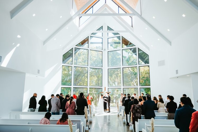wedding ceremony in front of large windows