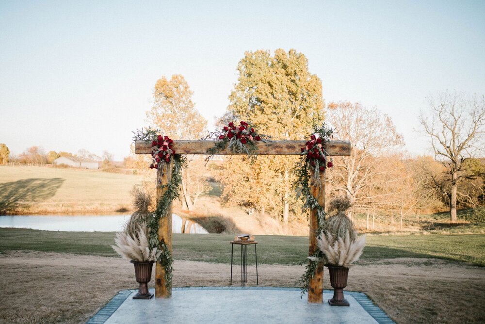 large wedding arch in front of pond