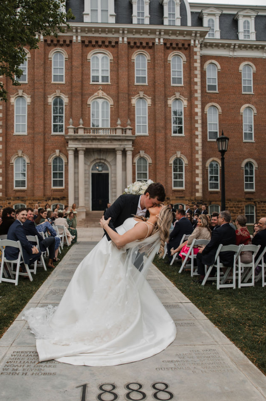 bride and groom kissing in front of historic venue