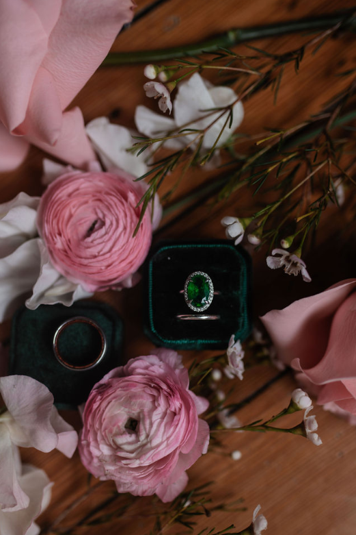 emerald wedding ring surrounded by pink flowers